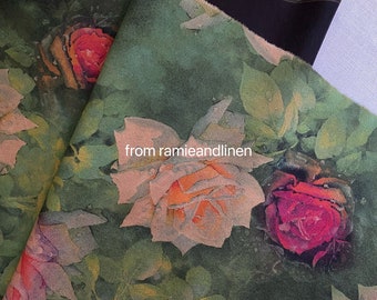 May include: Green fabric with a watercolor floral print featuring roses in shades of pink, red, and white. The fabric has a textured, linen-like appearance.