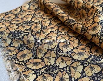 May include: A close-up of a fabric with a floral pattern. The fabric is black with a light brown floral design. The fabric is folded in half and the text "from ramieandlinen" is visible in the lower left corner.
