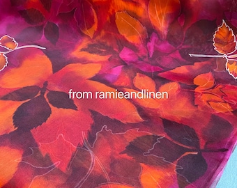 Op de afbeelding: Abstracte stof met een aquarelontwerp van oranje, roze en paarse bladeren. De stof heeft een doorschijnende, transparante kwaliteit. De tekst "from ramieandlinen" is zichtbaar in het midden van de afbeelding.