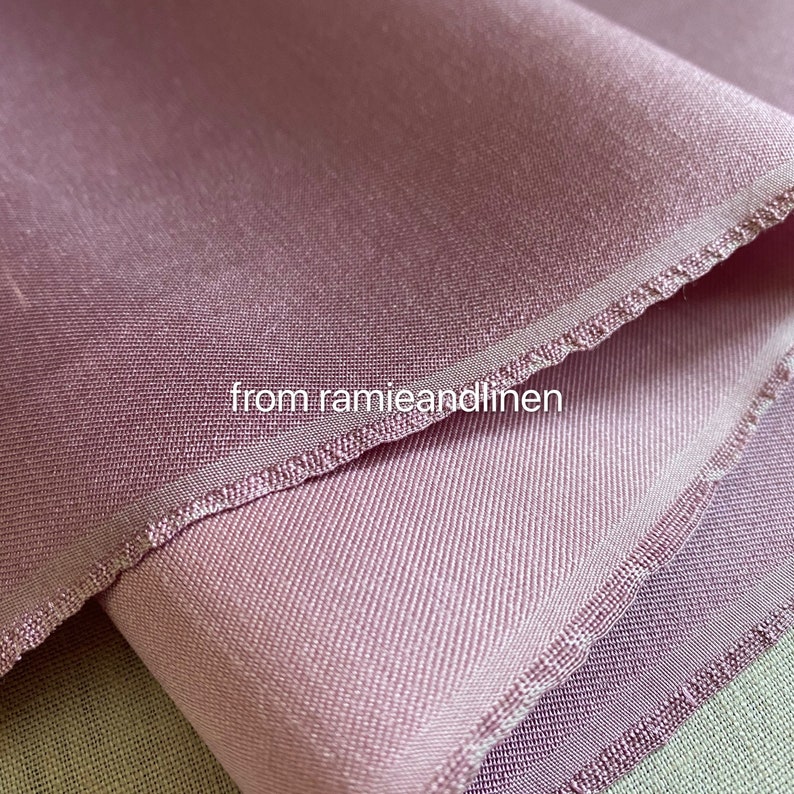 May include: Close-up of a soft, pink fabric with a subtle sheen. The fabric has a delicate, woven texture and a slightly textured edge. The text "from ramieandlinen" is visible in the lower center of the image.