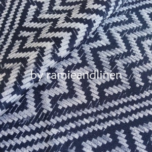 May include: A close-up of a dark blue and white patterned fabric with a geometric design. The fabric is soft and has a subtle sheen.