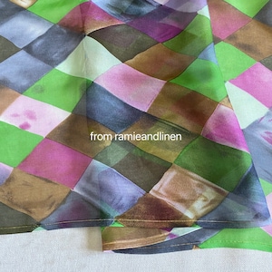 May include: A close-up of a fabric with a checkered pattern in shades of green, brown, pink, and blue. The fabric has a subtle sheen and a soft, flowing texture. The text "from ramieandlinen" is visible in the image.