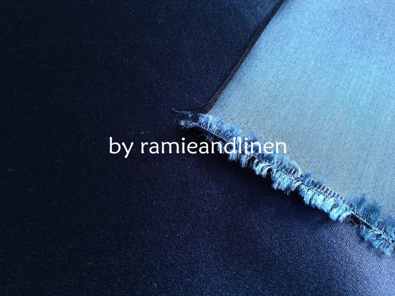 May include: Close-up of two different shades of blue denim fabric. The top fabric is a lighter shade of blue and has a frayed edge. The bottom fabric is a darker shade of blue. The text "by ramieandlinen" is visible in the image.