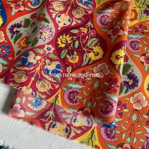 Könnte beinhalten: Roter, orangefarbener, gelber und blauer Blumenstoff mit Paisley-Muster. Der Stoff hat ein wellenförmiges Design und ist aus einem weichen, leichten Material gefertigt.