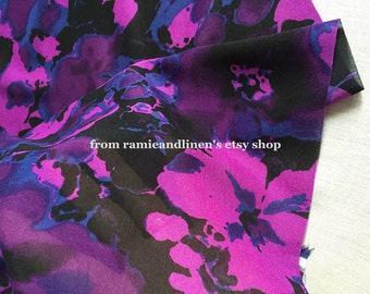 May include: Purple and black fabric with a floral print. The fabric has a soft, flowing texture and is perfect for creating garments or home decor.