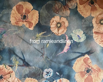 May include: A teal blue fabric with a floral pattern featuring large, orange-toned poppy flowers with brown centers. The fabric has a subtle watercolor effect and a textured linen-like appearance. The text "from ramieandlinen" is printed in white on the fabric.