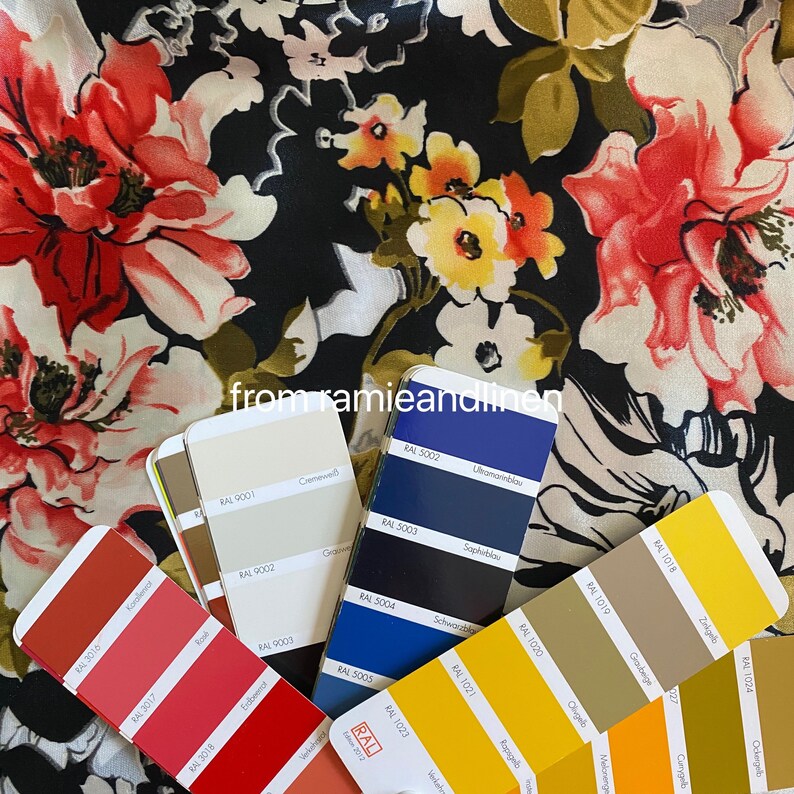 May include: A close-up of a fabric with a floral pattern in shades of red, yellow, and white on a black background.  The fabric is displayed with colour swatches from the RAL colour system, showing various shades of red, yellow, blue, and brown.