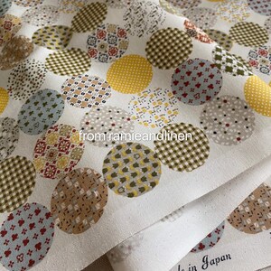 May include: White fabric with a repeating pattern of colorful circles. Each circle has a different pattern, including gingham, polka dots, and floral designs. The fabric is made of linen and ramie.