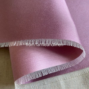 May include: Close-up of a soft, pink fabric with a subtle texture. The fabric has a raw edge and is folded over itself. The text "from ramieandlinen" is visible in the image.