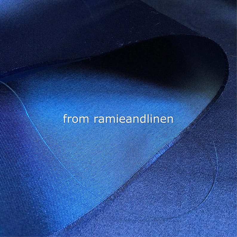 May include: Close-up of a dark blue fabric with a lighter blue fabric folded over it. The text "from ramieandlinen" is visible in the center of the image.