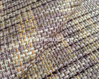 Puede incluir: Primer plano de una tela tejida con un patrón a cuadros marrón, beige y rosa. La tela es texturizada y tiene un brillo sutil. El texto "by ramieandlinen" es visible en la esquina inferior derecha de la imagen.
