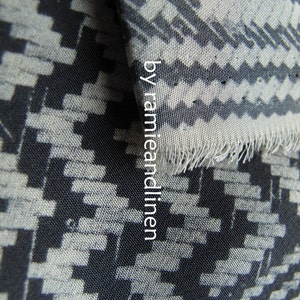 May include: Black and white geometric patterned fabric with a slightly textured surface. The fabric is woven with a repeating pattern of small squares and rectangles.