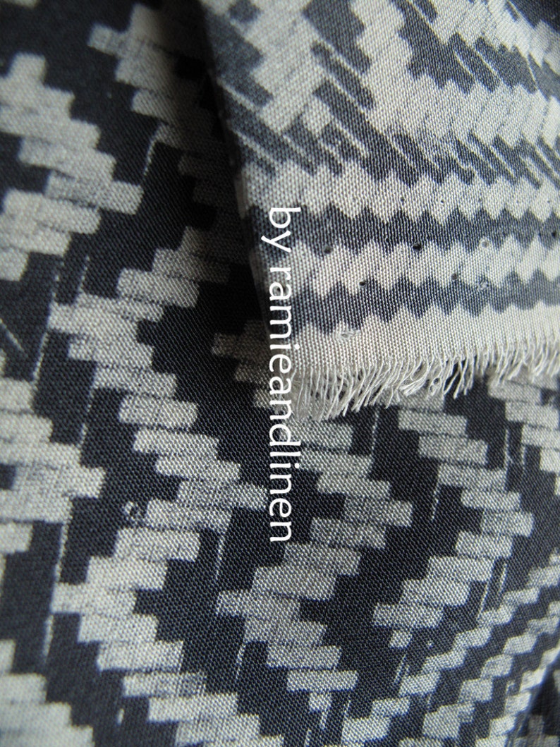May include: Black and white geometric patterned fabric with a slightly textured surface. The fabric is woven with a repeating pattern of small squares and rectangles.