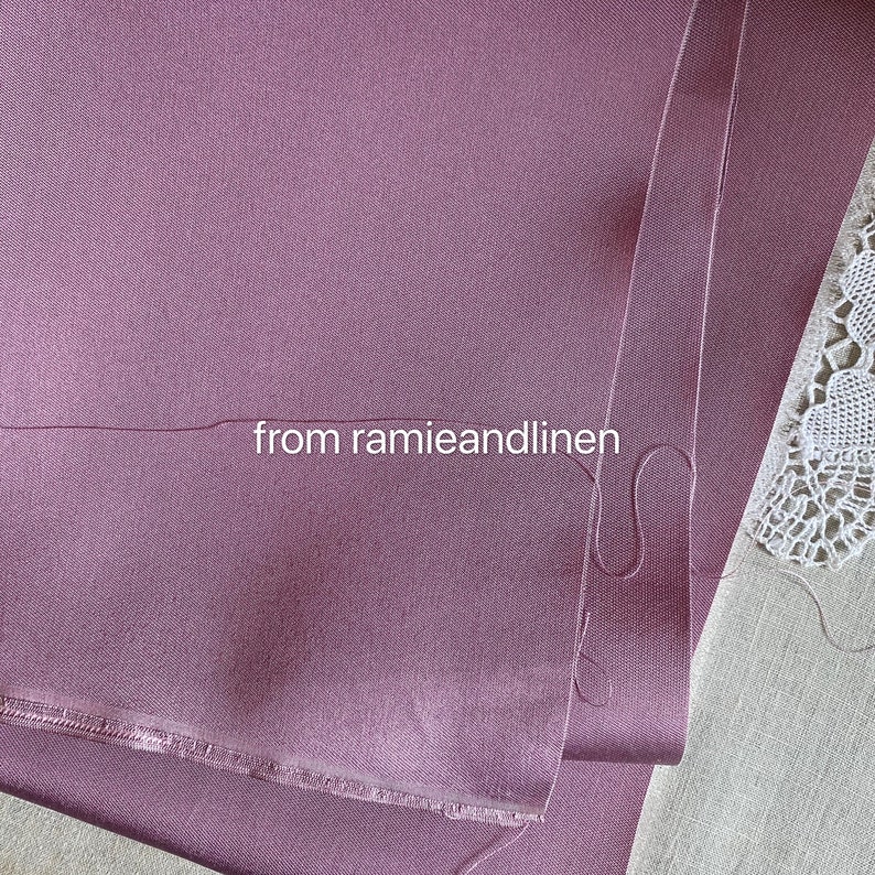 May include: Close-up of a folded piece of mauve fabric with a raw edge. The fabric is smooth and has a subtle sheen. The text "from ramieandlinen" is visible in the image.