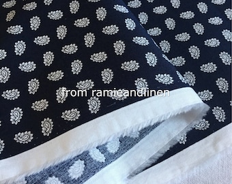 May include: White paisley print fabric on a dark blue background. The fabric has a white border and is folded in half.