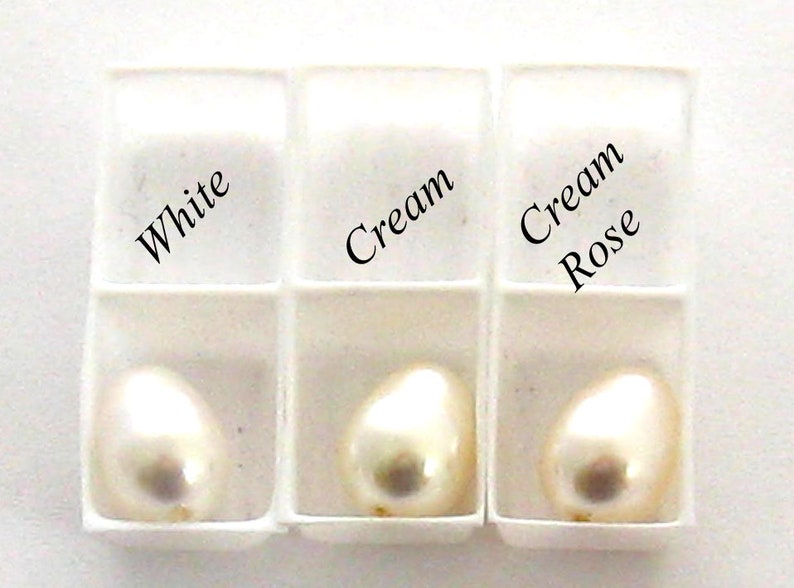 May include: Three white pearl samples in a white tray. The samples are labeled "White", "Cream", and "Cream Rose".