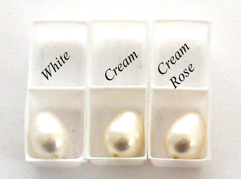 May include: Three white pearl samples in a white tray. The samples are labeled "White", "Cream", and "Cream Rose".