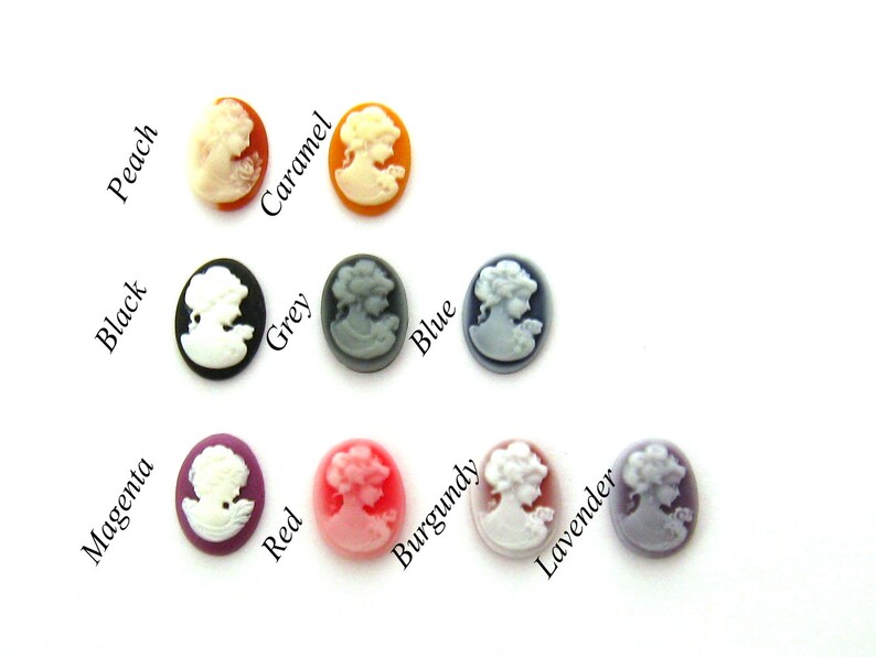 May include: Assortment of 12 cameo-style buttons in various colors, including black, grey, blue, red, burgundy, lavender, peach, caramel, and magenta. Each button features a white cameo profile.