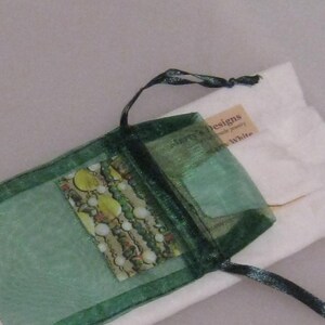 May include: A green organza bag with a drawstring closure. The bag contains a small printed card with the text "Sherry's Designs Handmade Jewelry" and "Sherry White".