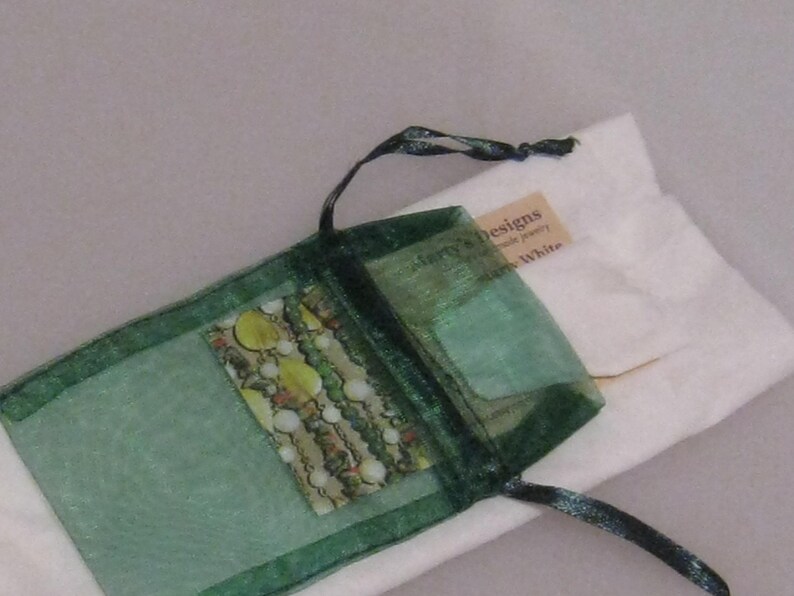 May include: A green organza bag with a drawstring closure. The bag contains a small printed card with the text "Sherry's Designs Handmade Jewelry" and "Sherry White".