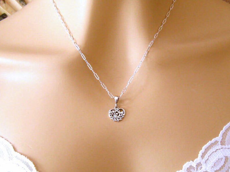 May include: A silver necklace with a heart pendant that says "Mom" on it.