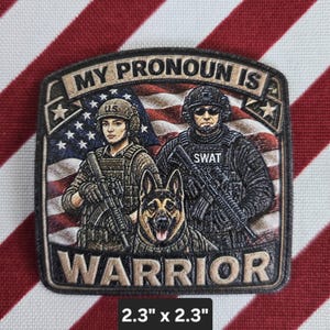 May include: A square embroidered patch measuring 2.3 inches by 2.3 inches featuring a US flag background, two tactical figures in gear, and a German Shepherd. The text reads MY PRONOUN IS WARRIOR. The patch has a dark border and tan lettering.