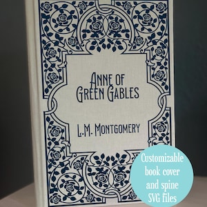 Könnte beinhalten: Ein Hardcover-Buch mit dem Titel "Anne of Green Gables" von L.M. Montgomery. Der Einband ist cremefarben mit einem dunkelblauen Blumendesign und Text. Ein hellblauer Kreis mit dem Text "Customizable book cover and spine SVG files" befindet sich unten rechts.