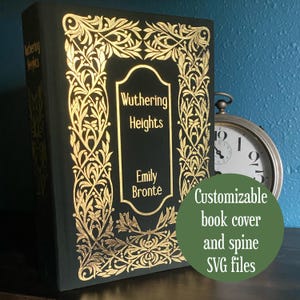 以下が含まれることがあります： エミリー・ブロンテの「嵐が丘」というタイトルと金色の花の模様が施された濃い緑色の本。本の背表紙にもタイトルが表示されています。背景には懐中時計があります。緑色の円には「カスタマイズ可能な本の表紙と背表紙のSVGファイル」と書かれています。