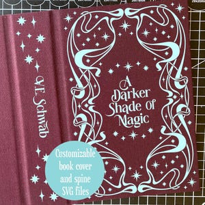 Può includere: Una copertina di libro bordeaux con il titolo "A Darker Shade of Magic" in scrittura bianca. La copertina presenta un design decorativo azzurro con stelle. Il nome dell'autore, V.E. Schwab, è stampato verticalmente. Un cerchio verde acqua recita "File SVG personalizzabili per copertina e dorso del libro."