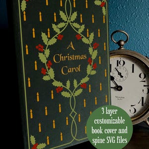 Op de afbeelding: Een donkergroene boekomslag met de titel "A Christmas Carol" in gouden letters, omgeven door een hulstkrans met rode bessen. De omslag is versierd met gele kaarsen. Een vintage klok staat op de achtergrond.