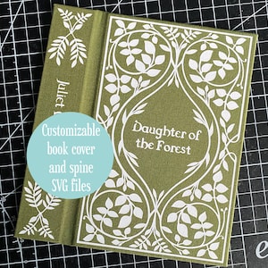 Könnte beinhalten: Ein grüner Buchumschlag mit weißen floralen Designs und dem Titel "Daughter of the Forest". Der Buchrücken trägt die Aufschrift "Juliet M". Ein hellblauer Kreis besagt "Anpassbare Buchumschlag- und Buchrückendateien (SVG).".