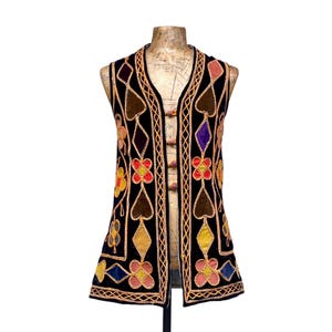 May include: A white ceramic mug with a black handle and the text "But first, coffee" in a handwritten style. The mug is on a white surface. The mug is approximately 4 inches tall.