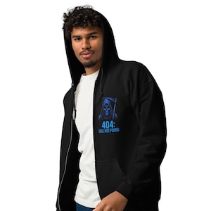 Puede incluir: Sudadera con capucha negra con cremallera y un gráfico azul de la muerte con la inscripción "404: SOUL NOT FOUND". La sudadera tiene capucha y cremallera completa. La persona lleva una camiseta blanca debajo.