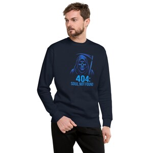Puede incluir: Sudadera azul marino con un gráfico azul de la Parca y el texto "404: SOUL NOT FOUND". La sudadera de cuello redondo tiene mangas largas. El gráfico está centrado en el pecho.