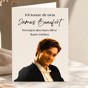 Könnte beinhalten: Eine weiße Grußkarte mit einem Foto einer Person mit dunklem Haar, die ein schwarzes Sakko und ein weißes Hemd trägt. Der Text auf der Karte lautet: Ich konnte dir nicht James Beaufort besorgen also muss diese Karte reichen.