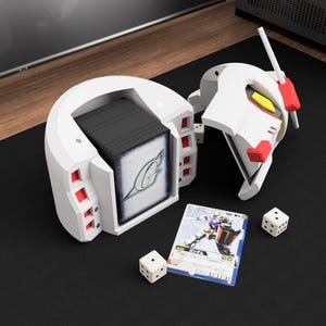 May include: A white and red Gundam-themed card holder, open to reveal a stack of cards. The holder is next to a Gundam head and two dice. A card with Japanese text and a robot illustration is also visible.