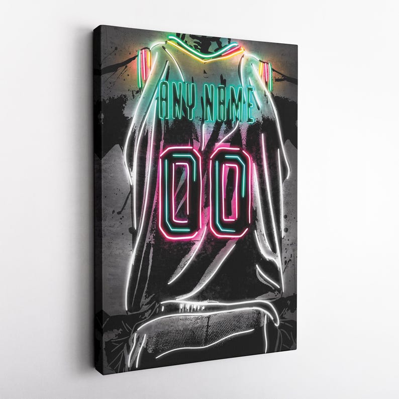 Op de afbeelding: Een canvas print van een basketbalshirt met een neon ontwerp. Het zwarte shirt heeft het nummer "00" in roze en groen neon. De tekst "ANY NAME" staat in groen neon. De achtergrond is donkergrijs met verfspetters.