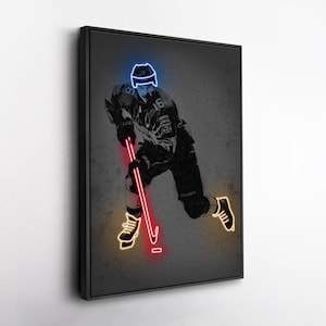 May include: A framed artwork featuring a hockey player in action, rendered in a neon-style design. The player is depicted in black and white, with neon blue and red accents highlighting the helmet, stick, and skates. The artwork is set against a textured gray background.
