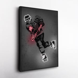 May include: Framed black and white artwork of a hockey player in action, with a neon red hockey stick and the number 19. The player is wearing a helmet and skates, with a gray background.