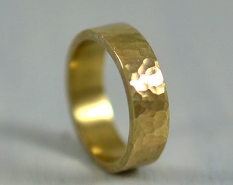 May include: A gold hammered band ring with a smooth, polished interior.