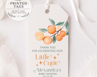 May include: A rectangular white paper gift tag with a white ribbon, featuring a watercolor illustration of oranges on a branch. The text reads: THANK YOU FOR CELEBRATING OUR Little Cutie Alexandra's BABY SHOWER 05.14.26, accented with small orange stars.