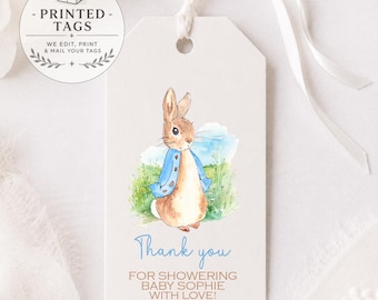May include: A rectangular white gift tag with a watercolor illustration of a brown rabbit wearing a blue jacket in a grassy field. The tag features the blue text Thank you and the brown text FOR SHOWERING BABY SOPHIE WITH LOVE! with a white ribbon.