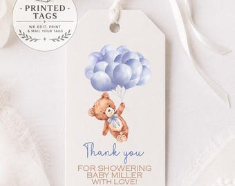 May include: A rectangular white gift tag with a white ribbon, featuring a watercolor illustration of a brown teddy bear holding a bunch of light blue balloons. The text reads Thank you FOR SHOWERING BABY MILLER WITH LOVE! in blue and brown ink.