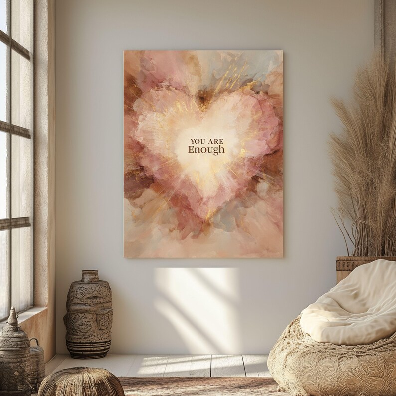 May include: A canvas print featuring a heart-shaped design with a soft, watercolor effect. The artwork uses a palette of pink, beige, and gold tones, with the words "YOU ARE Enough" in the center. The piece is displayed on a white wall.