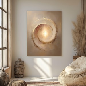 May include: Abstract canvas art featuring a spiral design with a bright, golden center. The artwork has a warm color palette of beige, gold, and brown tones. The painting is displayed on a white wall, creating a focal point in a room with natural light.