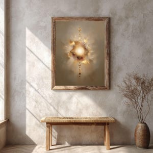 May include: Abstract art print in a wooden frame. The artwork features a central, bright, glowing light surrounded by soft, cloud-like shapes in shades of beige, gold, and brown. A series of small, golden orbs descends from the central light.