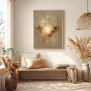 May include: Abstract art print in a wooden frame. The artwork features a central golden light surrounded by a circular design and soft, blended colors of beige, brown, and gold. The print hangs above a woven bench with pillows and decorative vases.