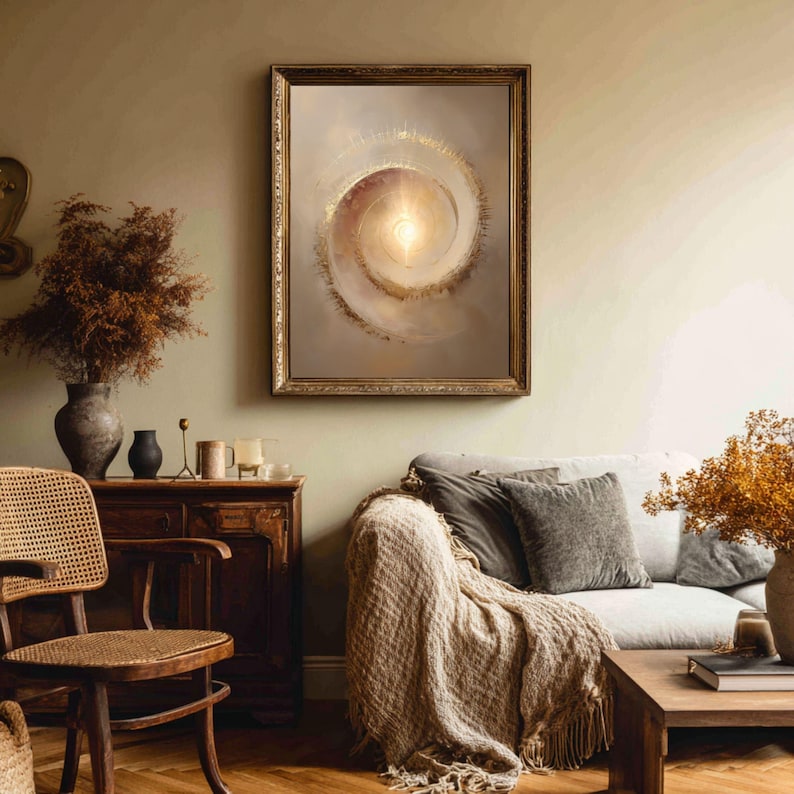May include: A framed abstract art print featuring a spiral design with a bright center. The artwork has a gold frame and is displayed in a living room setting with a sofa, wooden furniture, and decorative items.