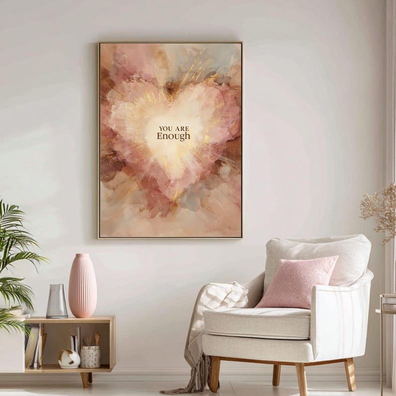 May include: Framed wall art featuring an abstract heart design in shades of pink, peach, and gold. The artwork includes the text "YOU ARE Enough" in a simple font. The piece is displayed in a gold frame, suitable for home decor.