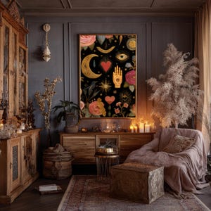 Peut inclure: Une impression d'art encadr&eacute;e avec un fond noir repr&eacute;sentant des &eacute;l&eacute;ments c&eacute;lestes et floraux. Des symboles de croissant de lune, de main et d'&eacute;toile dor&eacute;s sont mis en &eacute;vidence, ainsi que des roses roses et des c&oelig;urs rouges. L'&oelig;uvre est accroch&eacute;e dans une pi&egrave;ce sombre et confortable.